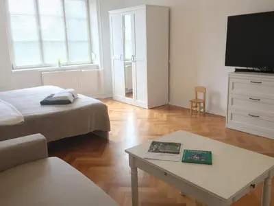 a living room with a bed and a coffee table at Historic Mexico Building Apartment in Ljubljana