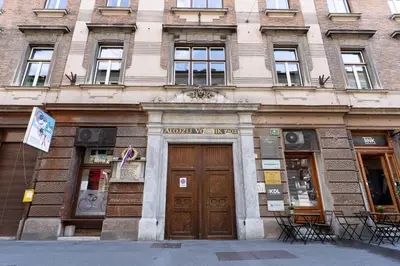a building with two wooden doors on a street at Kenti Residence in Ljubljana