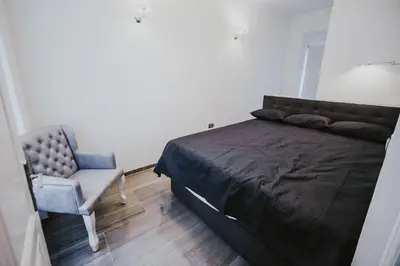 a bedroom with a bed and a chair at Kenti Residence in Ljubljana