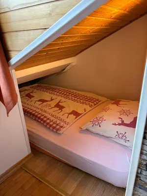 a bunk bed in a bunk bed under a stairs at Apartma Snežko in Kranjska Gora