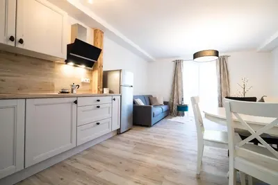 a kitchen with white cabinets and a dining room at Hiša 109 in Kranjska Gora