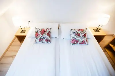 two beds in a room with two lamps at Hiša 109 in Kranjska Gora