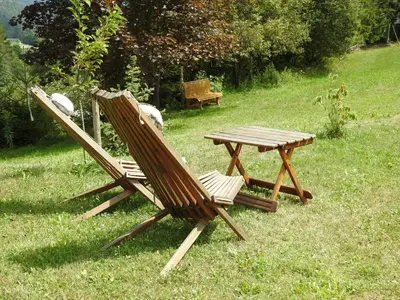 two chairs and a picnic table in the grass at Hiša 109 in Kranjska Gora