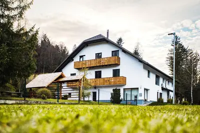 a white house with a balcony on the side of it at Hiša 109 in Kranjska Gora