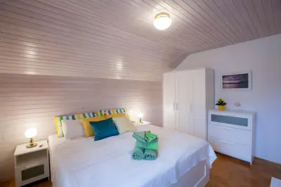 a bedroom with a large white bed with blue pillows at Apartments Special Bled in Bled