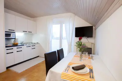 a kitchen and dining room with a table and chairs at Apartments Special Bled in Bled