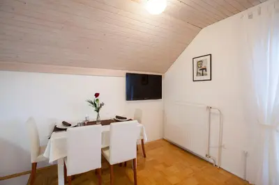 a dining room with a white table and white chairs at Apartments Special Bled in Bled