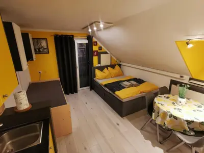 a small bedroom with a bed and a table at Apartma LINA, Encijan D-38 in Bohinj