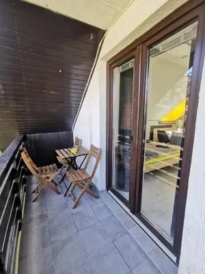 a patio with two chairs and a table on a balcony at Apartma LINA, Encijan D-38 in Bohinj
