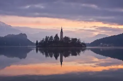 a church on an island in the middle of a lake at Apartma LINA, Encijan D-38 in Bohinj