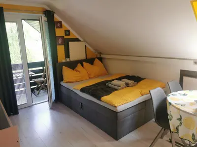 a small bedroom with a bed with yellow sheets at Apartma LINA, Encijan D-38 in Bohinj
