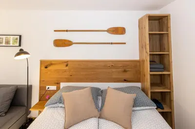 a bedroom with a bed with a wooden headboard at Old Boatman's House in Bled