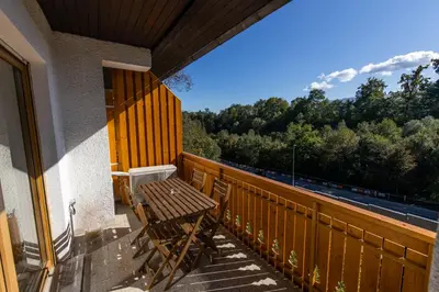 a wooden bench on a balcony with a view of a train at Old Boatman's House in Bled