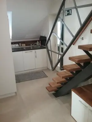 a kitchen with white cabinets and a staircase at Hudinja 111 in Vitanje