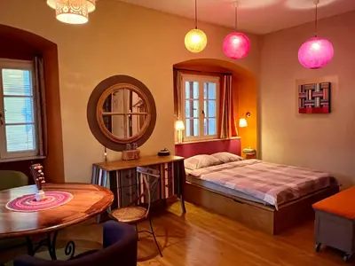 a bedroom with a bed and a table and a mirror at MuziKafe - Home of Culture in Ptuj