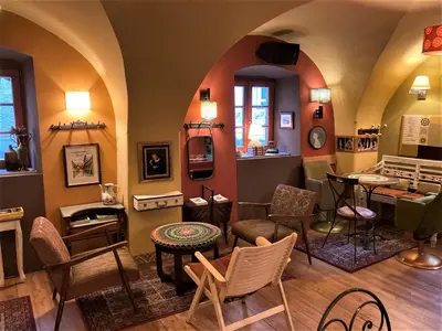 a room with chairs and tables in a room at MuziKafe - Home of Culture in Ptuj