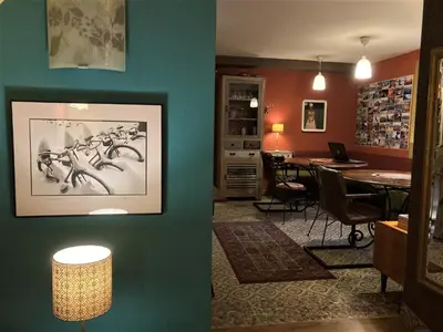 a living room with a blue wall with a table at MuziKafe - Home of Culture in Ptuj