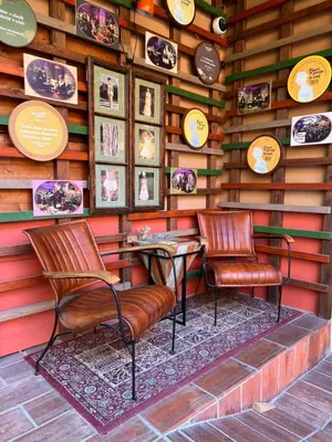a restaurant with two chairs and a wall with pictures at MuziKafe - Home of Culture in Ptuj