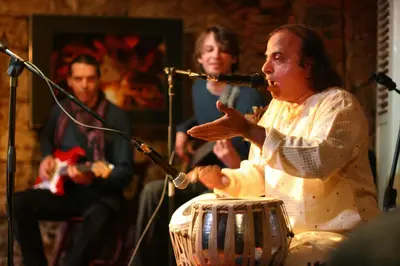a woman singing into a microphone next to a drum at MuziKafe - Home of Culture in Ptuj