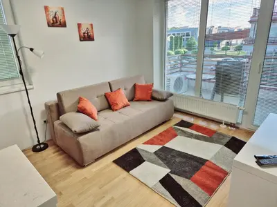 a living room with a couch and a large window at Apartmaji PANONIA 