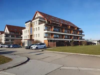 a large building with cars parked in a parking lot at Apartmaji PANONIA 
