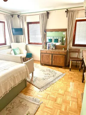a bedroom with a bed and a desk and a mirror at Guesthouse Sabine - pr` Skminc in Bohinjska Bela