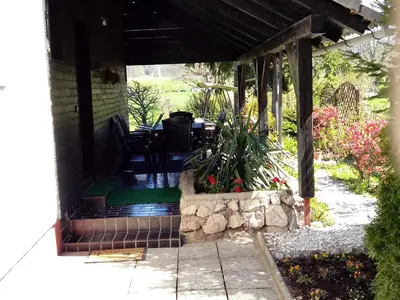 a porch with a table and chairs and flowers at Aparthouse Ani in Radovljica