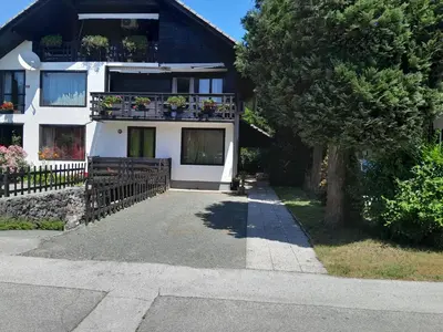 a house with a balcony with potted plants on it at Aparthouse Ani in Radovljica