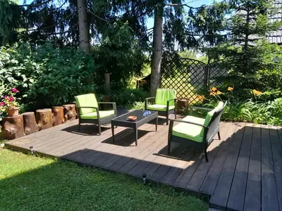 three chairs and a table on a wooden deck at Aparthouse Ani in Radovljica