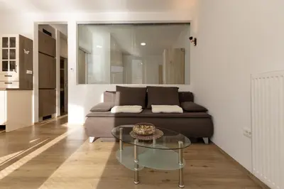 a living room with a couch and a glass table at Apartmaji 