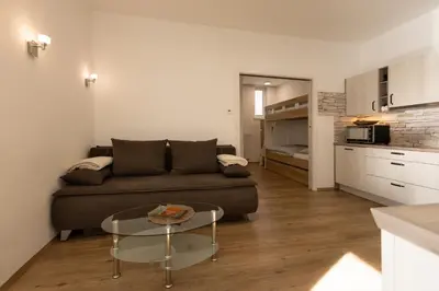 a living room with a couch and a table at Apartmaji 