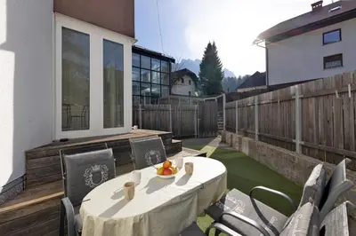 a patio with a table and chairs on a balcony at Apartmaji 