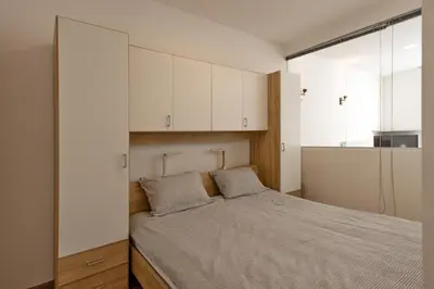 a bedroom with a bed with white cabinets at Apartmaji 