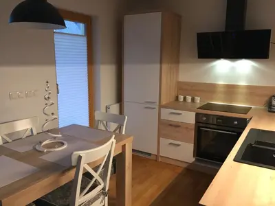 a kitchen with a table with chairs and a dining room at Apartma Pika in Mojstrana