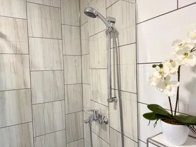 a shower with a shower head in a bathroom at Guest house Kobal in Spodnje Gorje