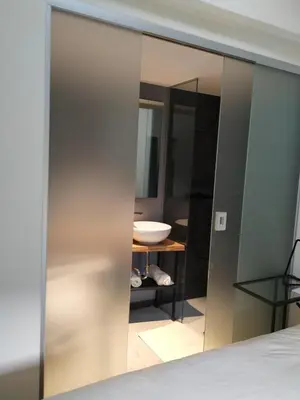 a sliding glass door with a bathroom in the background at B & W KRIŽ in Ajdovščina