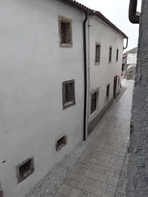 a white building with windows on the side of a street at B & W KRIŽ in Ajdovščina