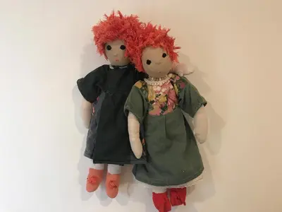 two dolls with red hair sitting on a wall at Klinar - Cosy apartment with a terrace in Bled