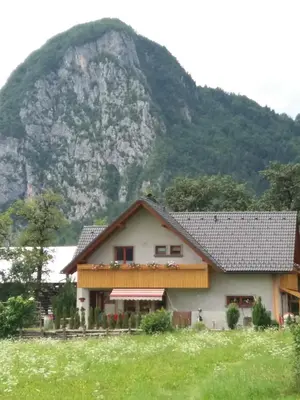 a house in front of a mountain at APARTMA BREMEC-STUDIO in Bohinj