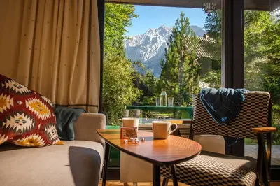 a room with a table and chairs and a large window at Idyllic cottage in beautiful Alps in Zgornje Jezersko