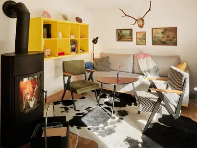 a living room with a couch and a stove at Idyllic cottage in beautiful Alps in Zgornje Jezersko