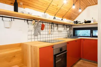 a kitchen with orange cabinets and a stove top oven at Idyllic cottage in beautiful Alps in Zgornje Jezersko
