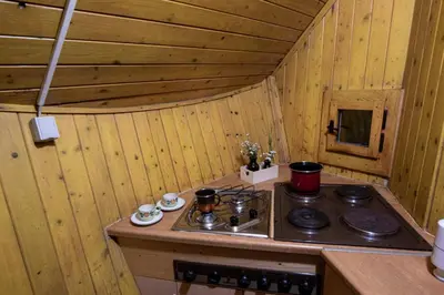 a kitchen with a stove in a wooden room at Chalet Gasparjeva Velika Planina in Kamnik