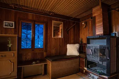 a living room with a stove and a window at Chalet Gasparjeva Velika Planina in Kamnik
