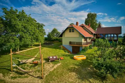 a house with a play yard with a playground at Holiday house Podhamer Boris in Presika