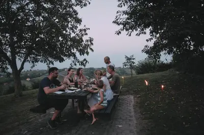 a group of people sitting at a picnic table at Holiday house Podhamer Boris in Presika
