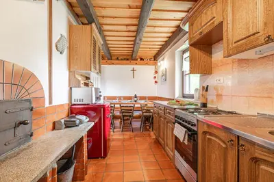 a kitchen with wooden cabinets and a red refrigerator at Holiday house Podhamer Boris in Presika