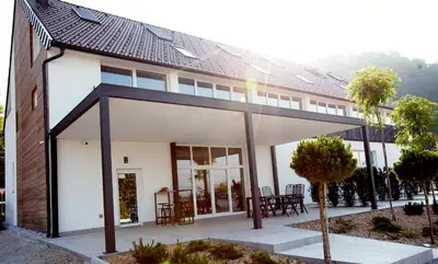 a large white house with a roof at Apartments The Art House in Škofljica