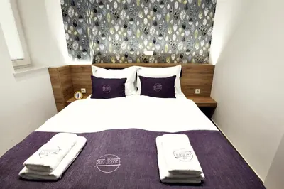 a bedroom with a bed with two towels on it at Apartments The Art House in Škofljica