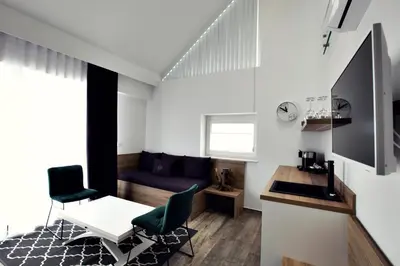a living room with a couch and a table and chairs at Apartments The Art House in Škofljica